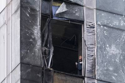 An investigator examines a damaged skyscraper in Moscow City business district after a reported drone attack in Moscow, Russia, Wednesday, Aug. 23, 2023.